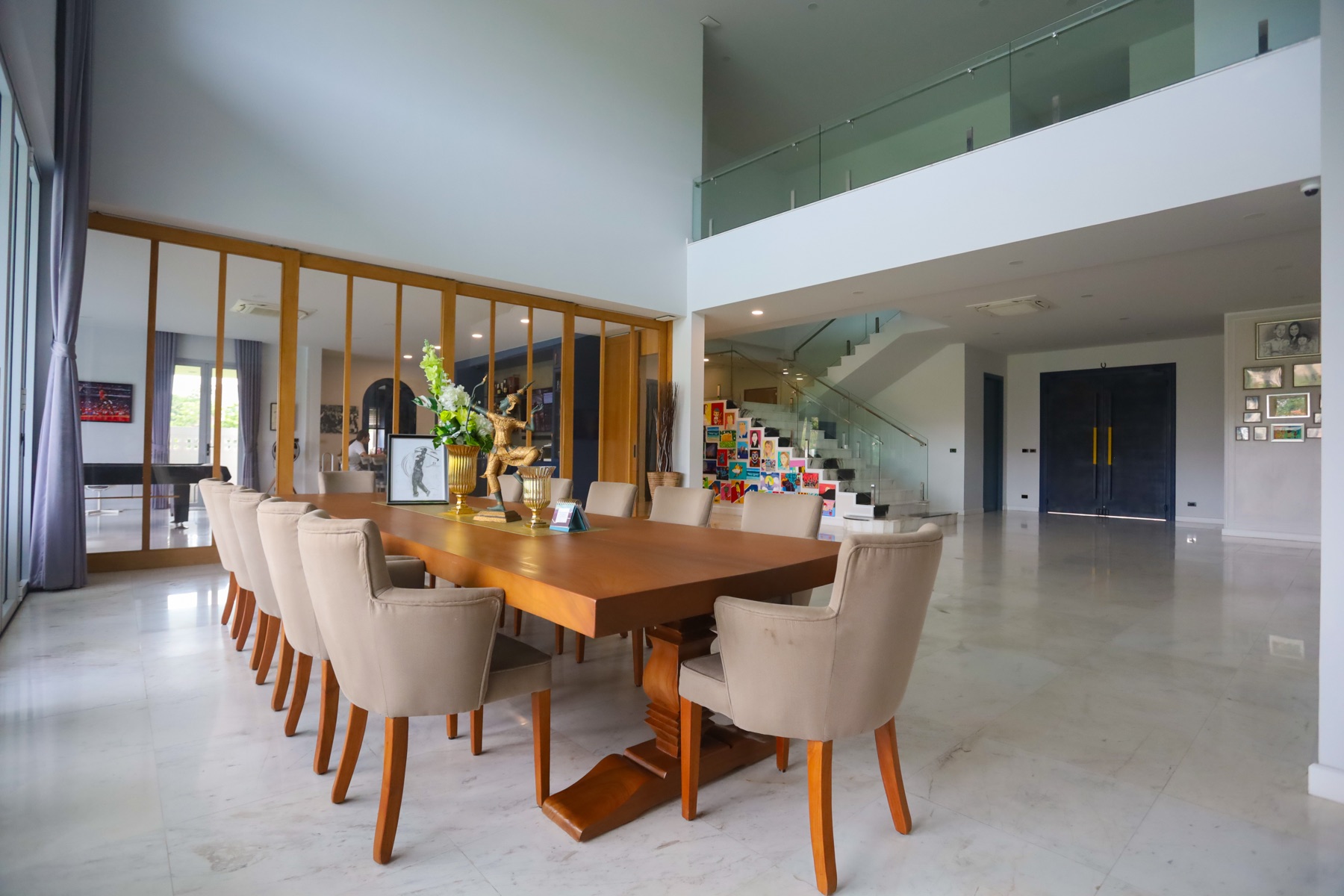 Grand dining area seating twelve, beneath a mezzanine balcony