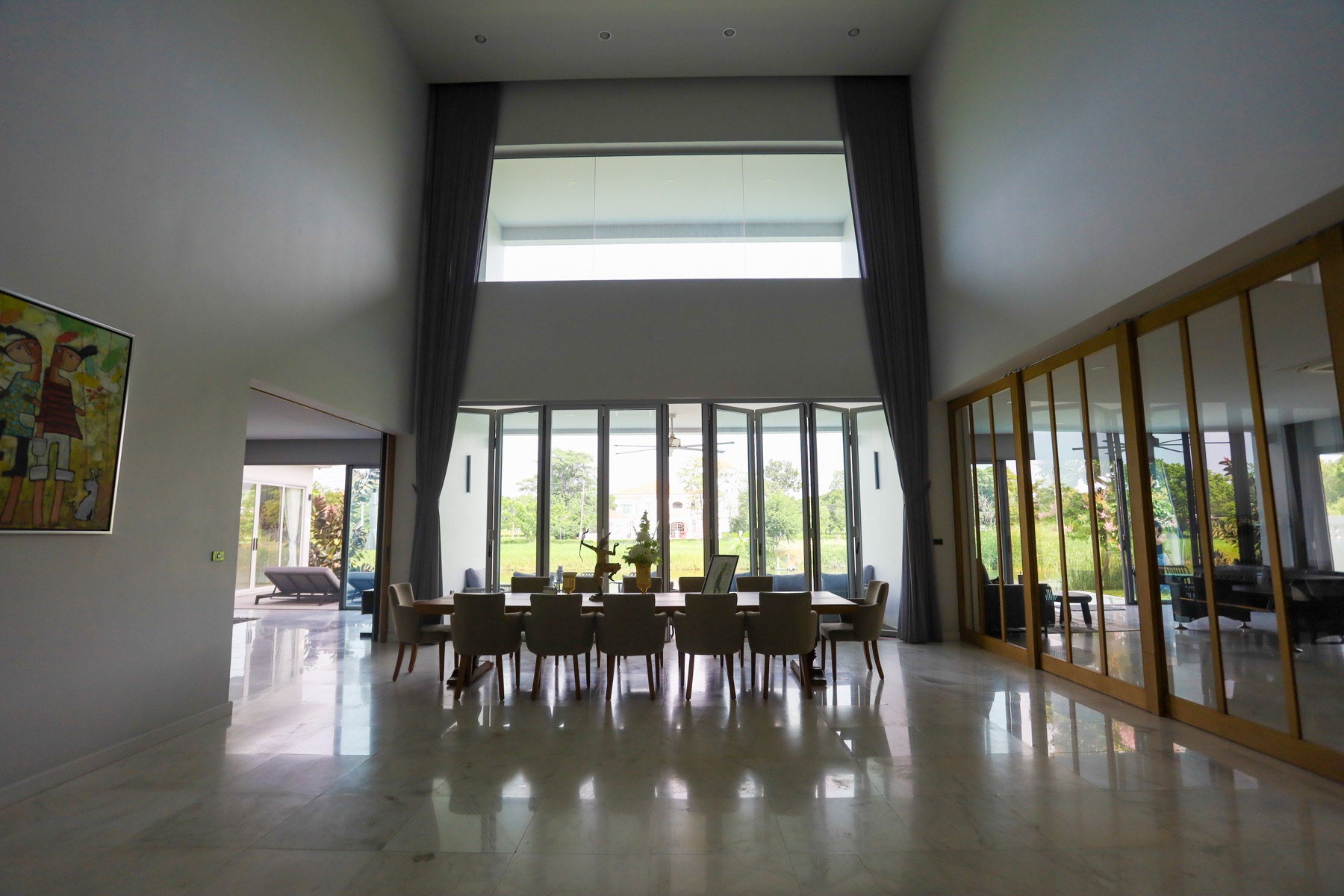 Great room with soaring 10-meter ceilings and full-height glass doors to the garden
