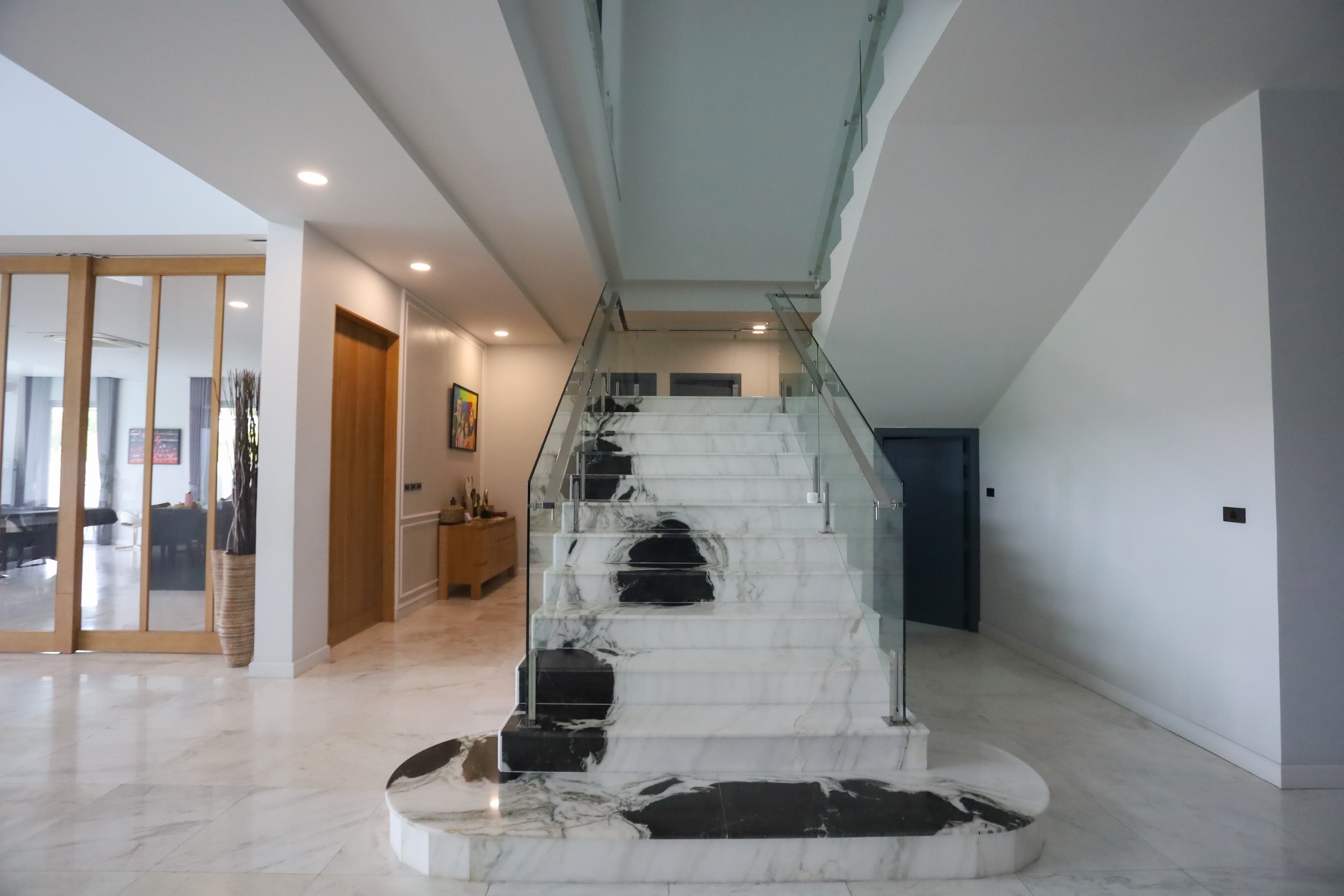 Italian marble staircase with glass balustrade in the entry hall